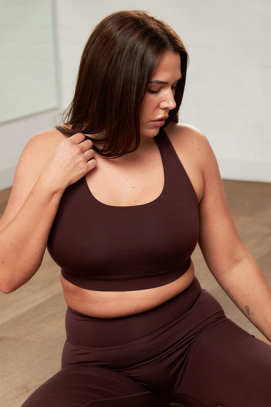 Close-up of ultra-fine merino sports bra strap resting against bare skin on the shoulder