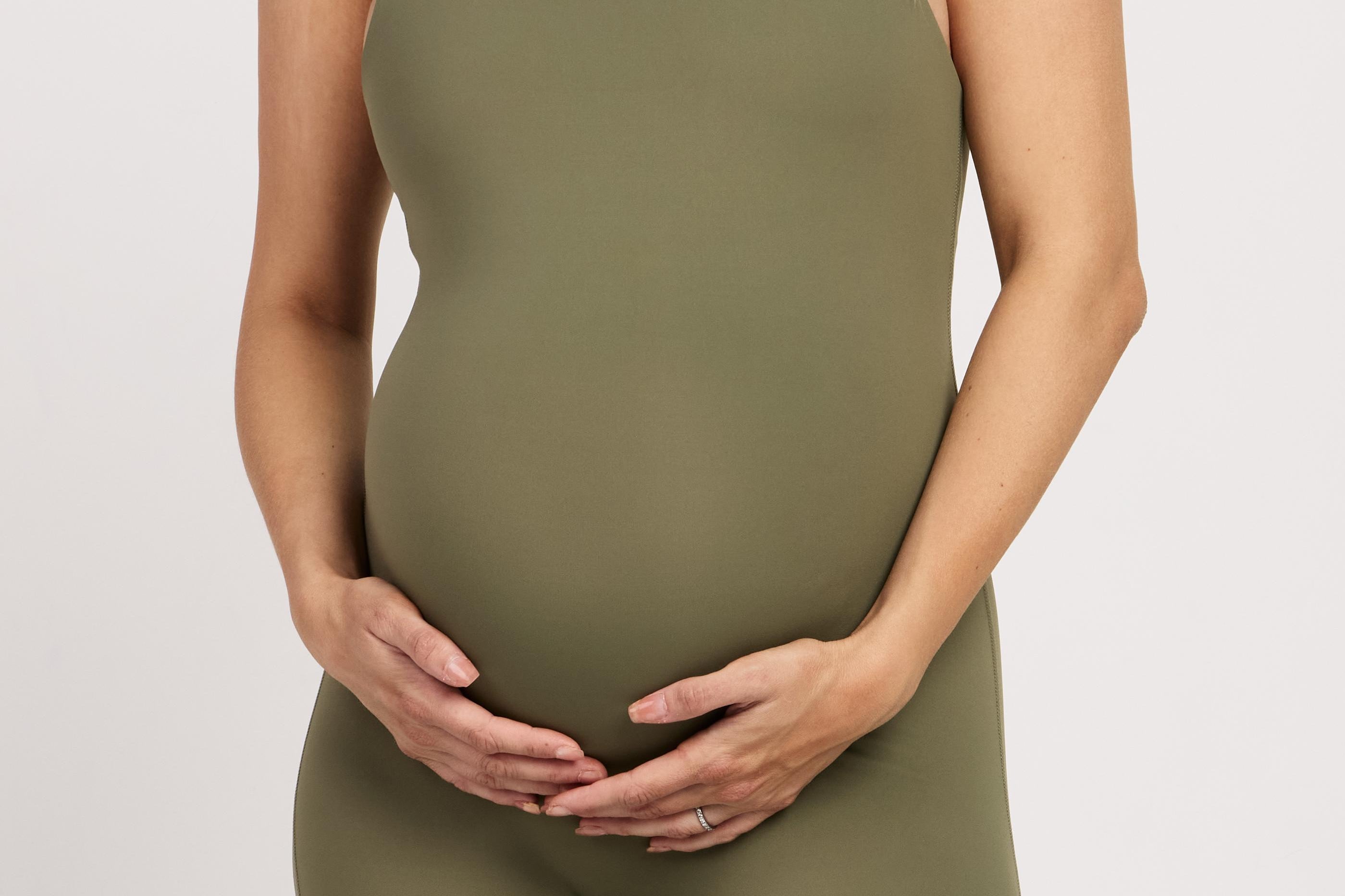 Stretchy sleeveless bodysuit with built-in bra, offering full-length coverage and breathable fabric for pregnancy comfort